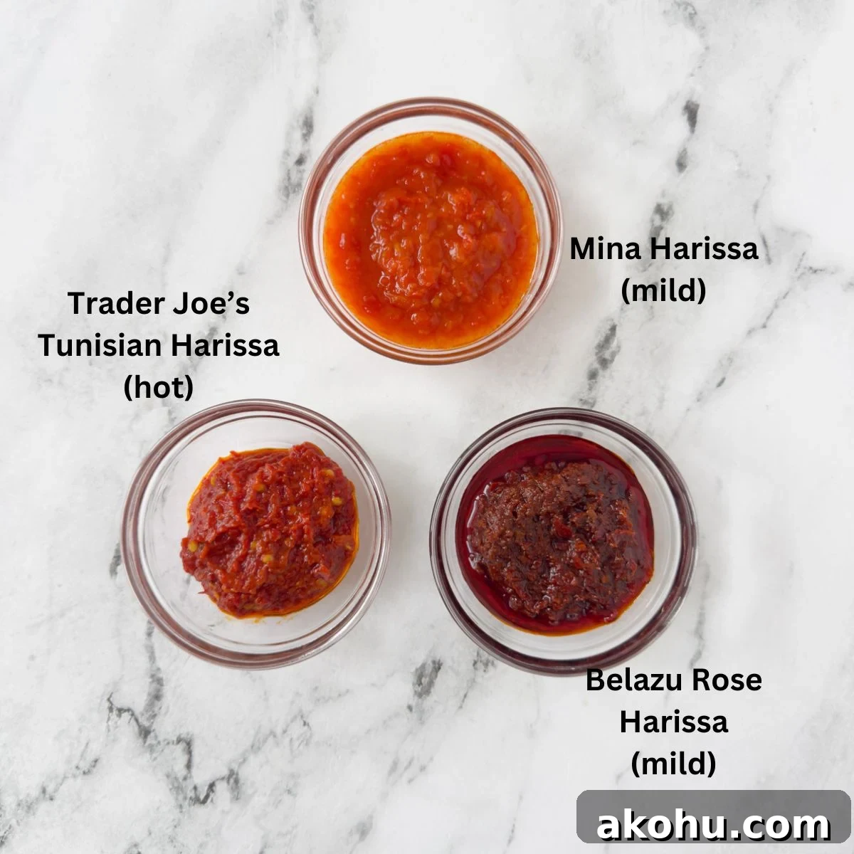 Three brands of Harissa paste in small glass bowls.