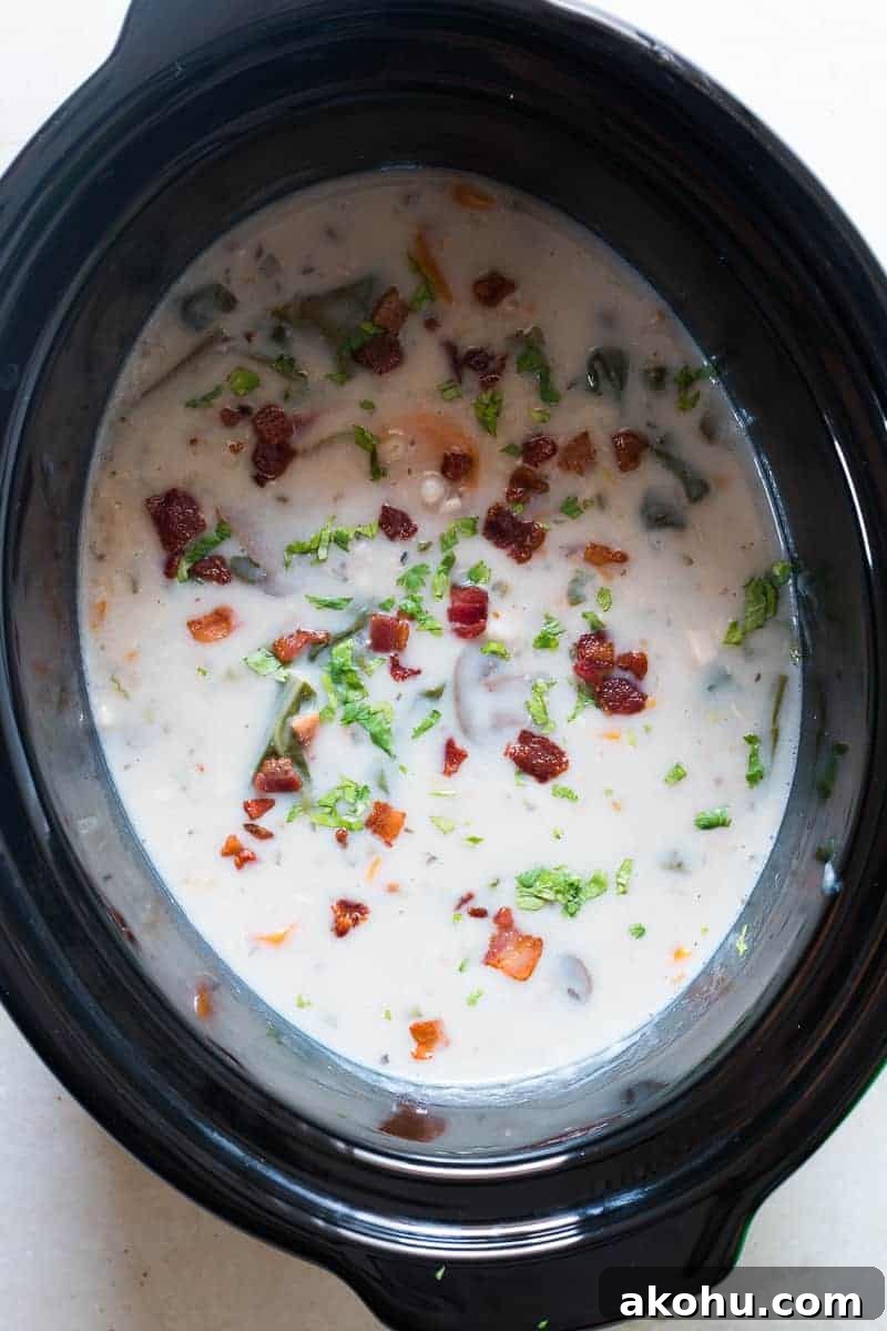 Bowl of creamy chicken barley soup, garnished and ready to serve.