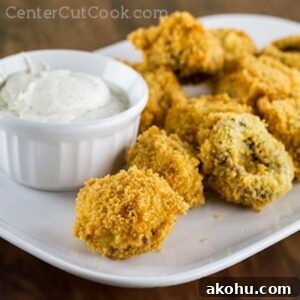 plate of crispy breaded mushrooms with dipping sauce on the side