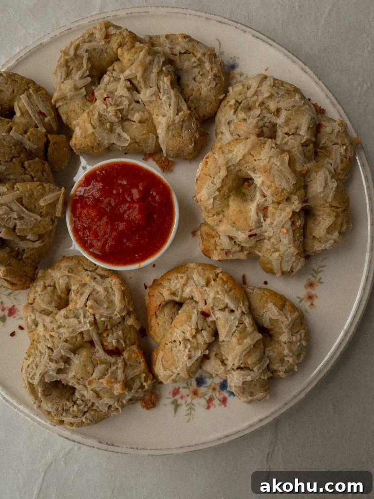 soft pizza pretzels on a white floral plate with small bowl of marinara 