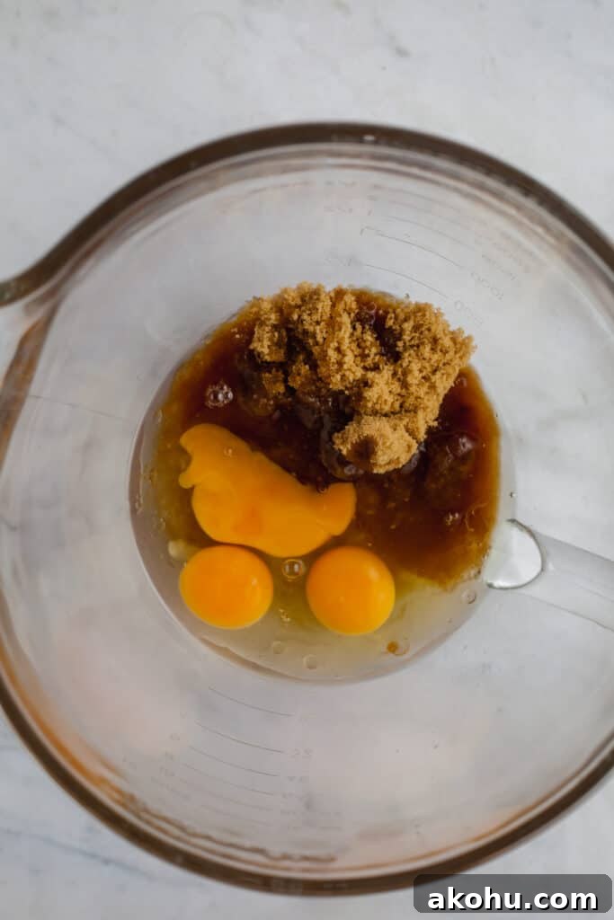 A large glass bowl with sugar and eggs