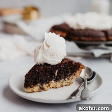a slice of brookie pie with cream on top on a small plate