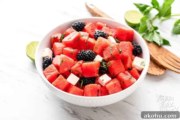 Watermelon Blackberry Feta Salad in a large white bowl with wooden tongs
