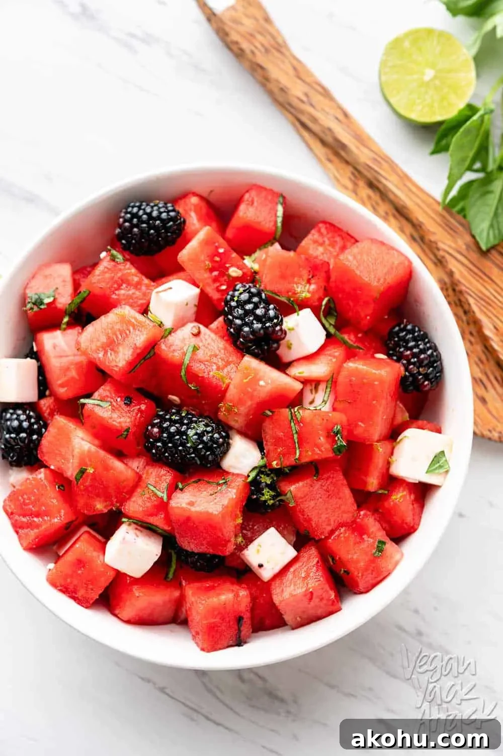 Watermelon Blackberry Feta Salad in a large white bowl with wooden tongs