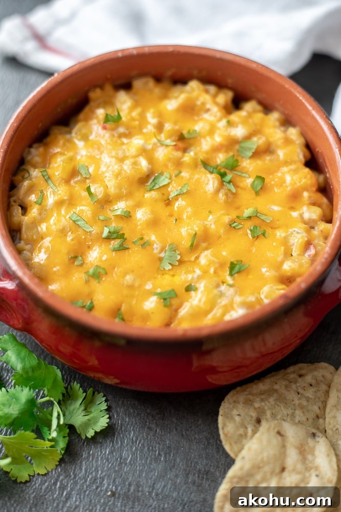 Hot Corn Dip baked in a red crock topped with minced cilantro.