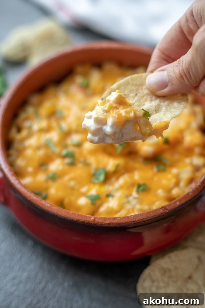 Chip scooping out Hot Mexican Corn Dip.