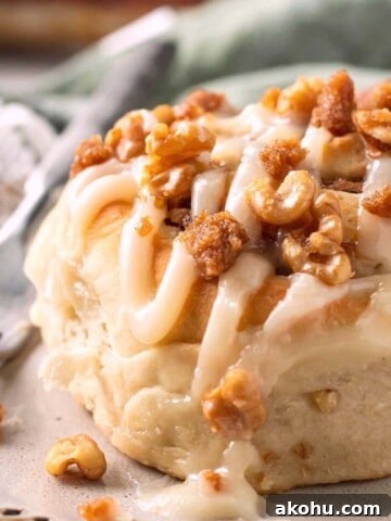 Baked Banana cinnamon roll with icing on plate with fork.