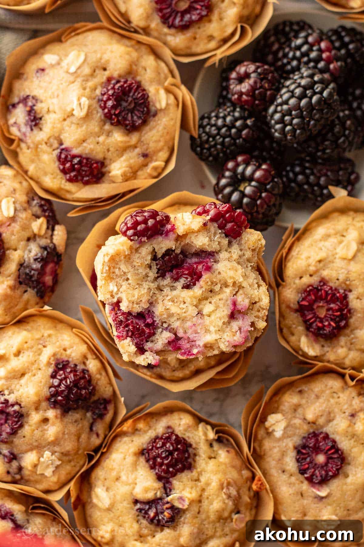 Banana Blackberry Oatmeal Muffins Recipe — Quick Baked Breakfast 10 Half of a blackberry banana oatmeal muffin stacked on another baked muffin.