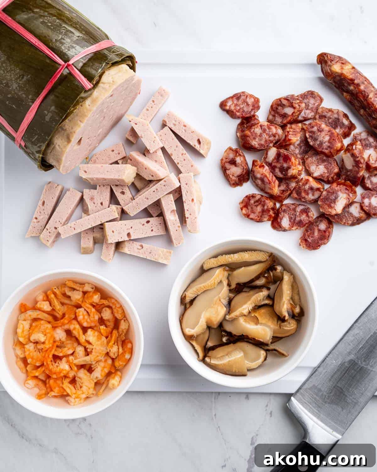 Cutting board with sliced pork loaf, chinese sausage. Bowls of dried shrimp and mushrooms soaking in water.