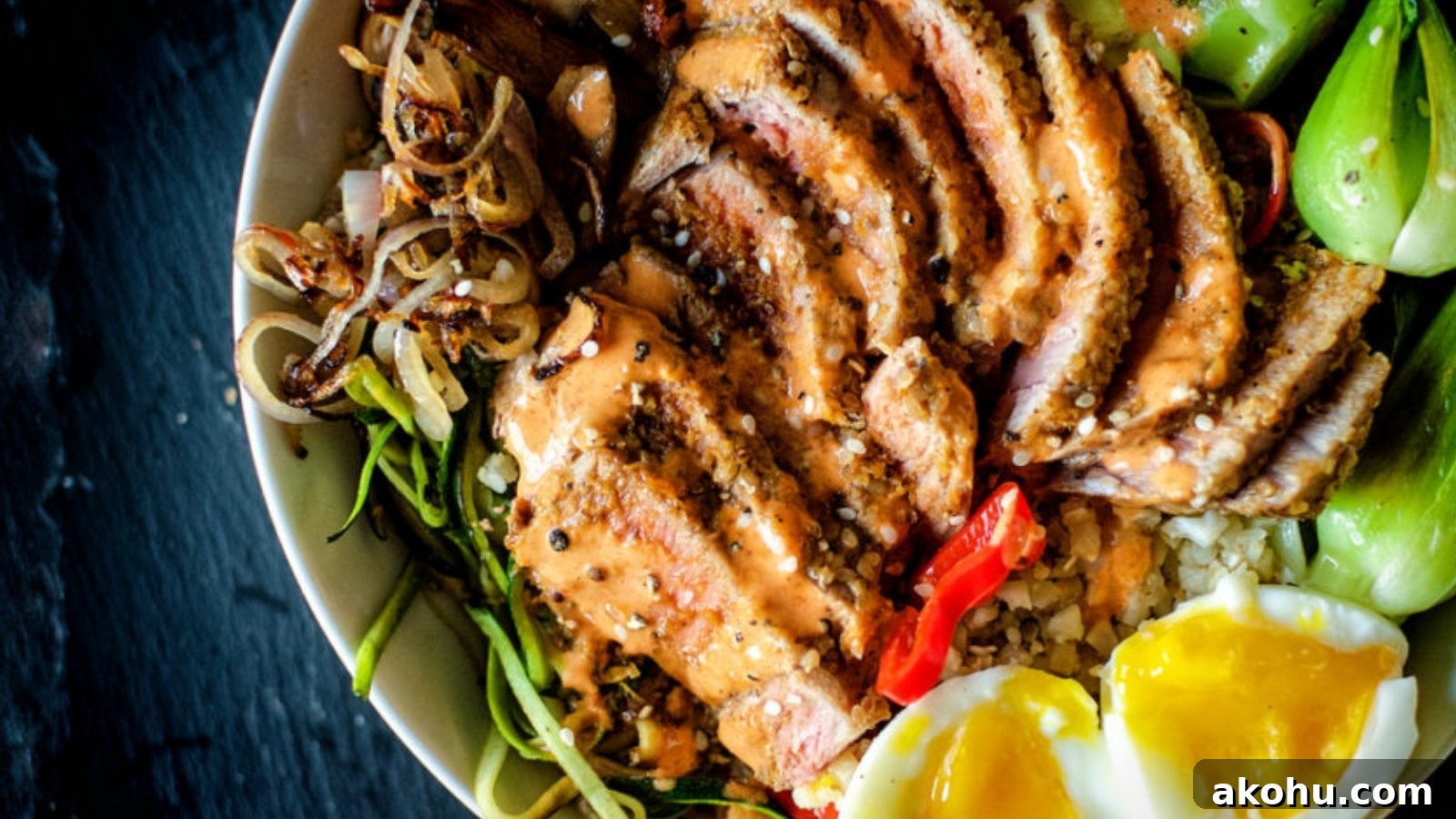 Tuna bowl with sesame crusted tuna slices over rice and vegetables.