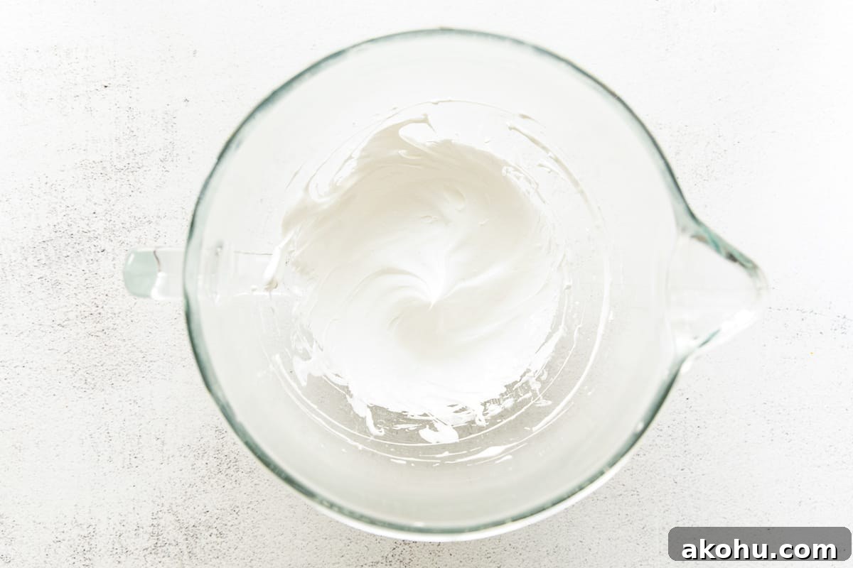 How to Make Adorable Meringue Ghosts for Halloween Treats 10 Whipped egg whites in a bowl.