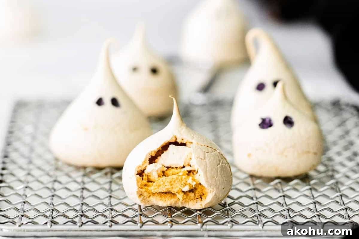 How to Make Adorable Meringue Ghosts for Halloween Treats 3 a cracked meringue cookie showing the inside texture on a wire rack next to in tact ghost meringues.
