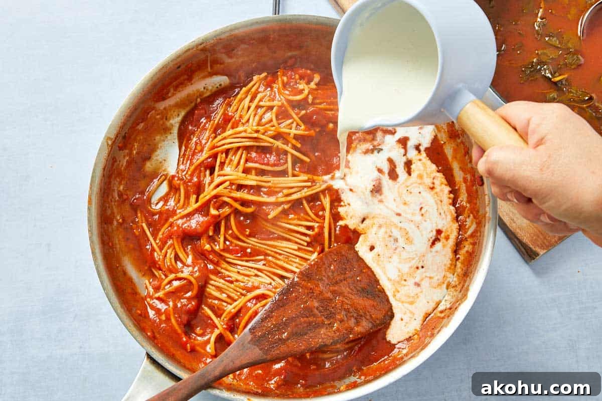 Heavy cream poured into the pasta sauce, transforming it into the signature pink.