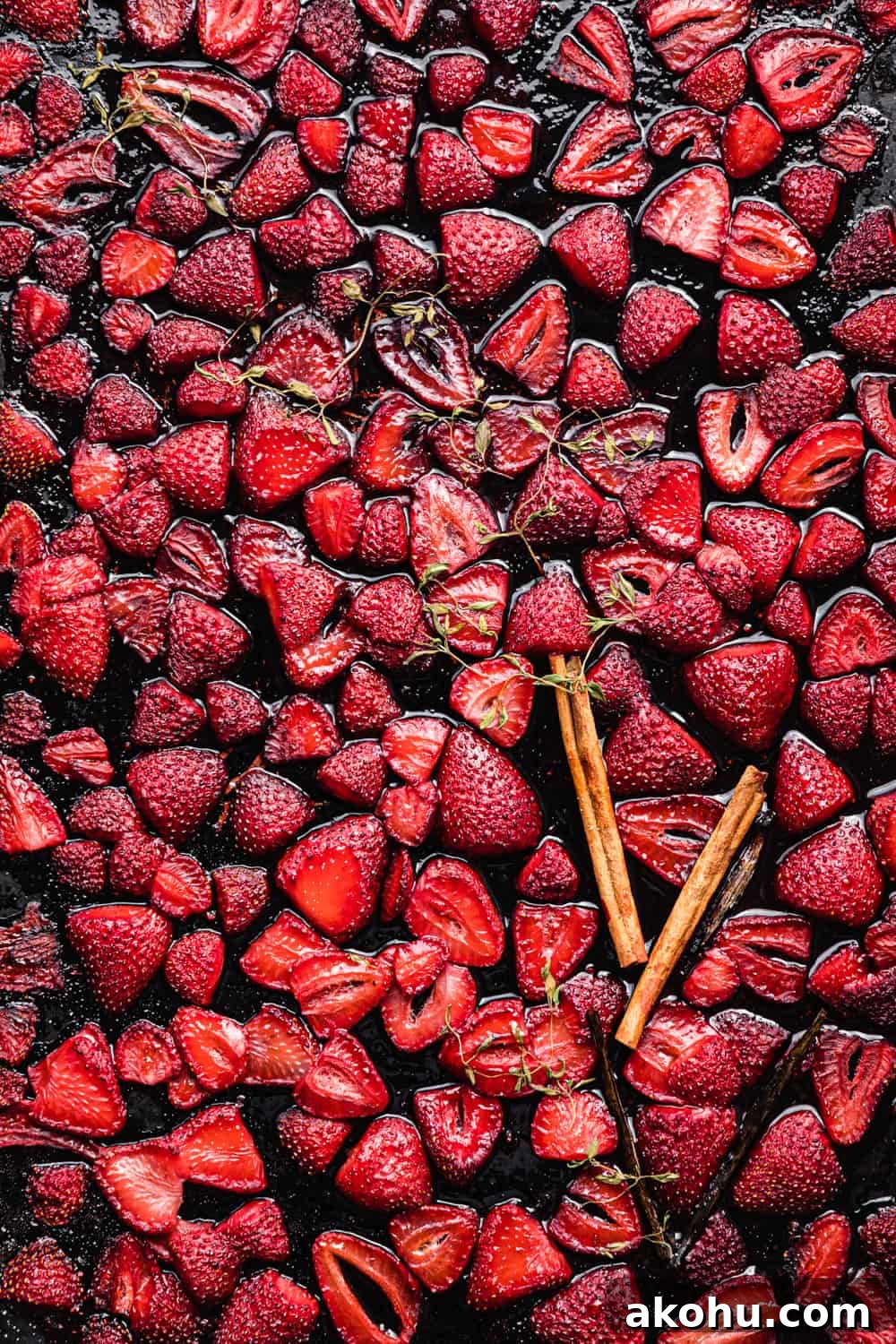roasted strawberries with cinnamon sticks, vanilla beans and thyme on a baking sheet.