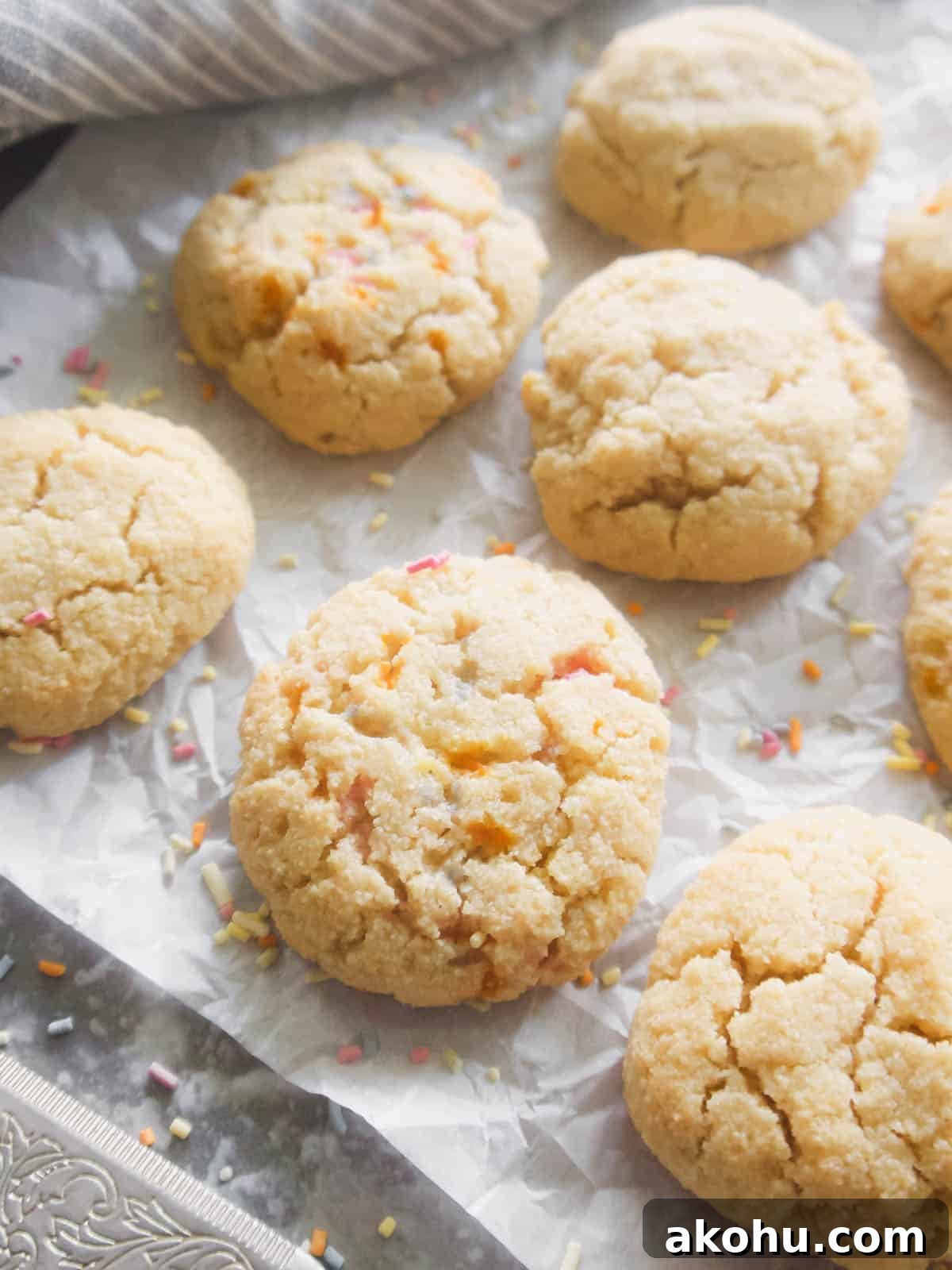 Paleo sugar cookies on parchment paper with sprinkles.