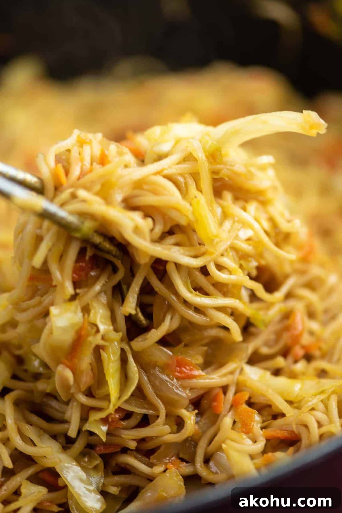 cabbage stir fry being pulled from a pan with tongs