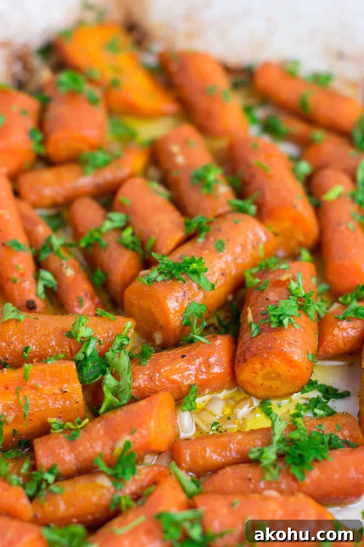 Garlic butter roasted carrots recipe with fresh parsley. A delicious vegan friendly side dish recipe that will disappear in minutes! #vegan #roastedcarrots #garlicbutter #garlicbuttercarrots #sidedishes #vegetables