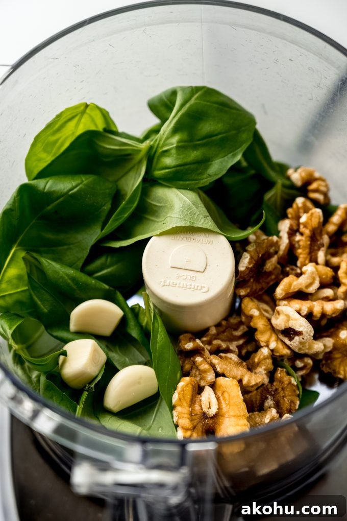 The ingredients to make pesto in the drum of a food processor.