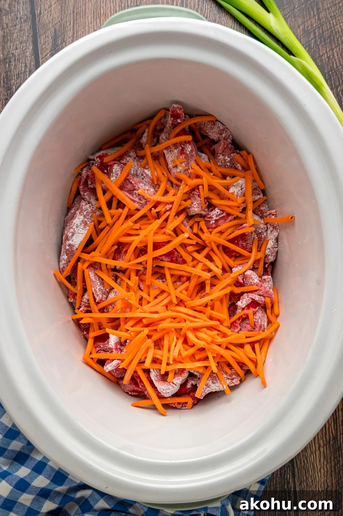 Slow Cooker Mongolian Beef Recipe — Tender Garlic Soy Beef 5 cornstarch coated flank steak and carrots added to a crockpot.