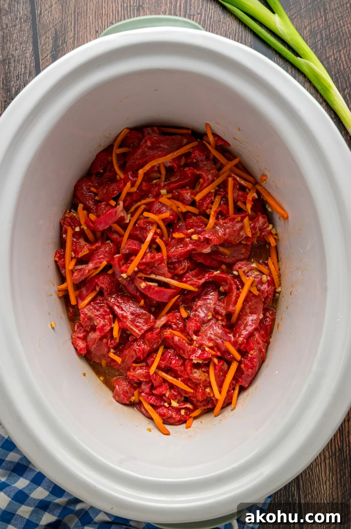 Slow Cooker Mongolian Beef Recipe — Tender Garlic Soy Beef 7 flank steak, carrots, and sauce stirred together.
