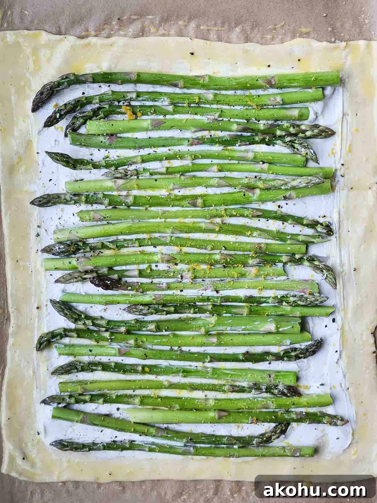 Asparagus and Whipped Goat Cheese Puff Pastry Tart 3 Uncooked puff pastry with goat cheese and asparagus on top.