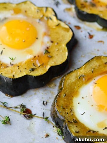 Angled view of acorn squash egg in a hole with thyme.