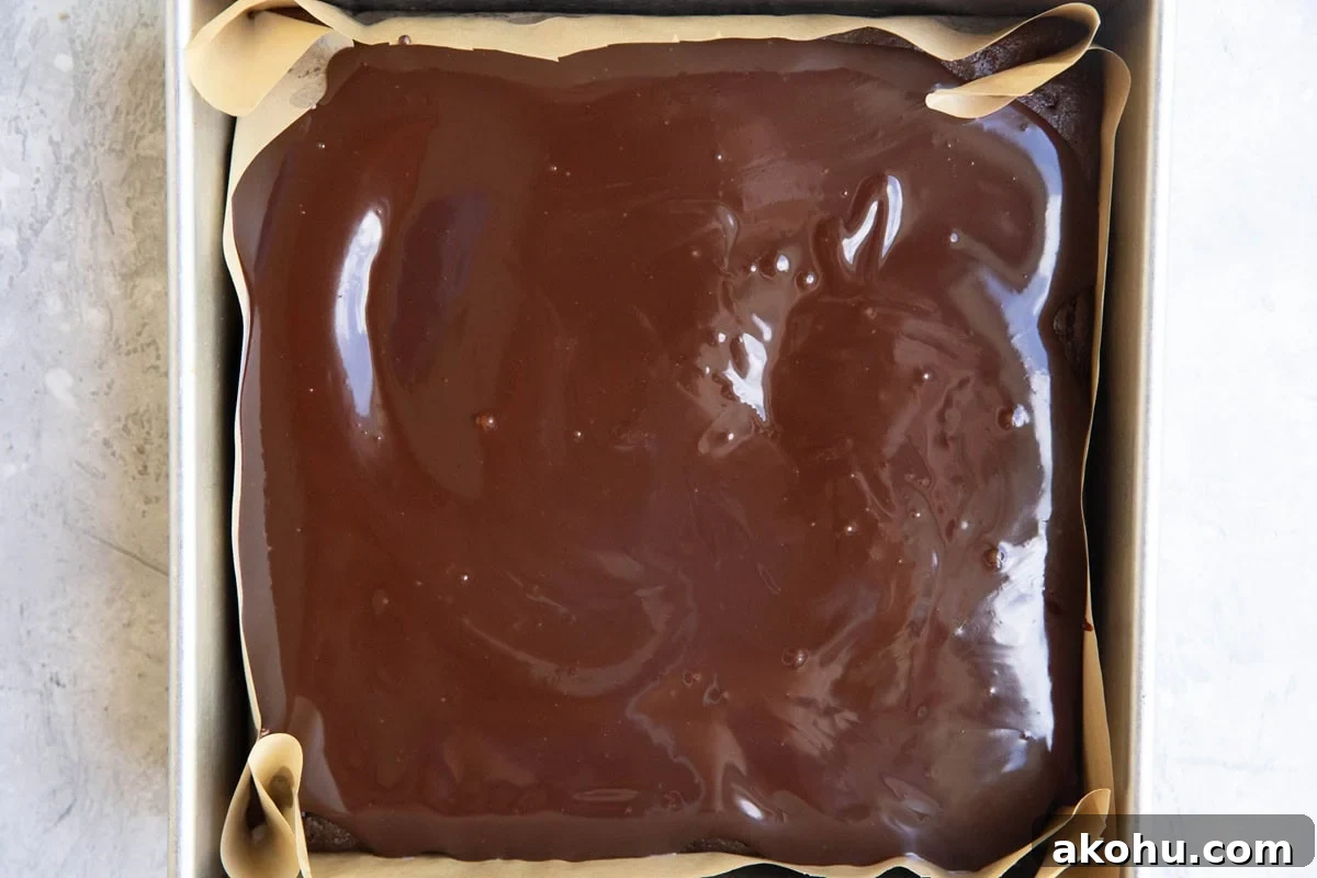 Cake pan with chocolate cake covered in chocolate ganache.