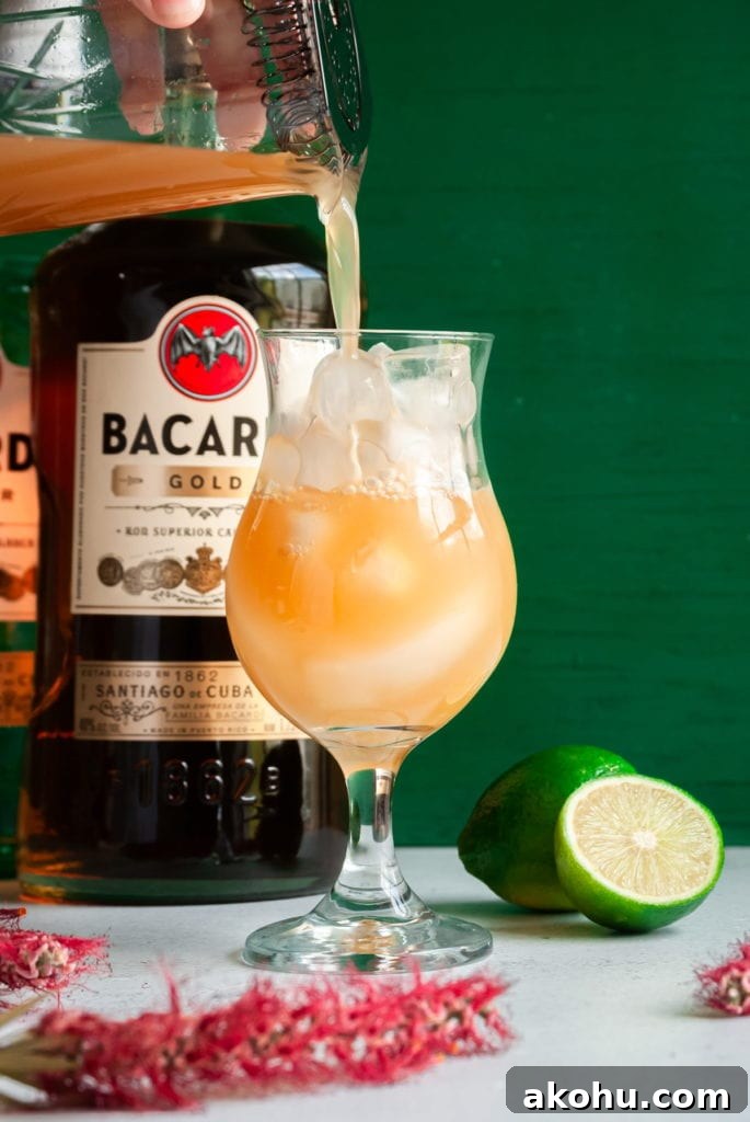 Refreshing Bacardi Rum Punch Recipe for Parties 6 pouring rum punch into glass with ice