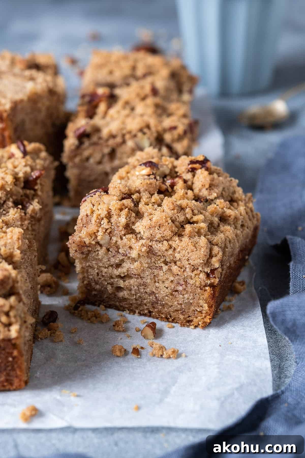 A square of vegan banana crumb cake with an espresso cup and spoon in the background.
