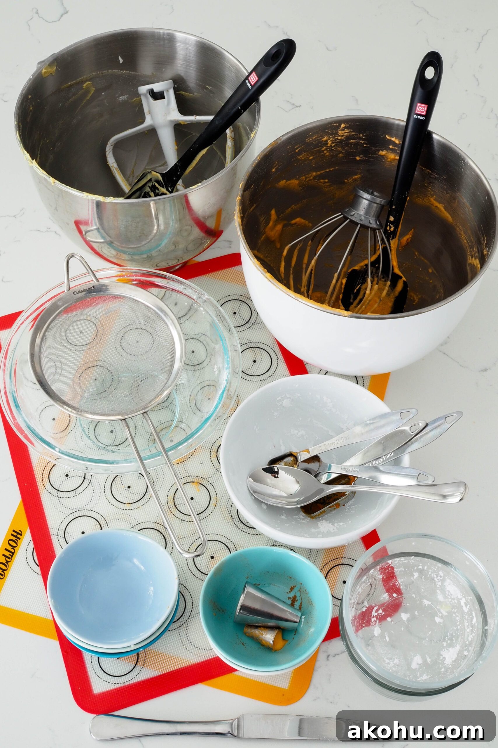 A collection of dishes and utensils used to make pumpkin spice macarons.