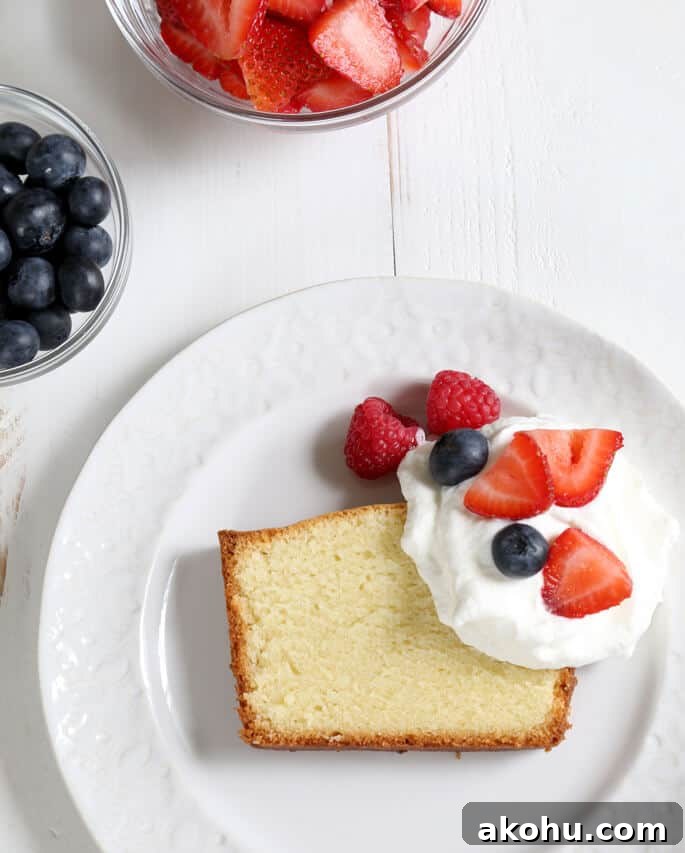 Overhead view of gluten free pound cake, whip cream and fruit on a white plate