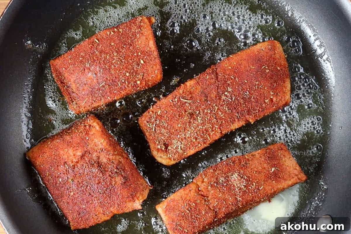 Pan-Seared Salmon with Fresh Mango Salsa 9 seasoned salmon filets in non stick pan.