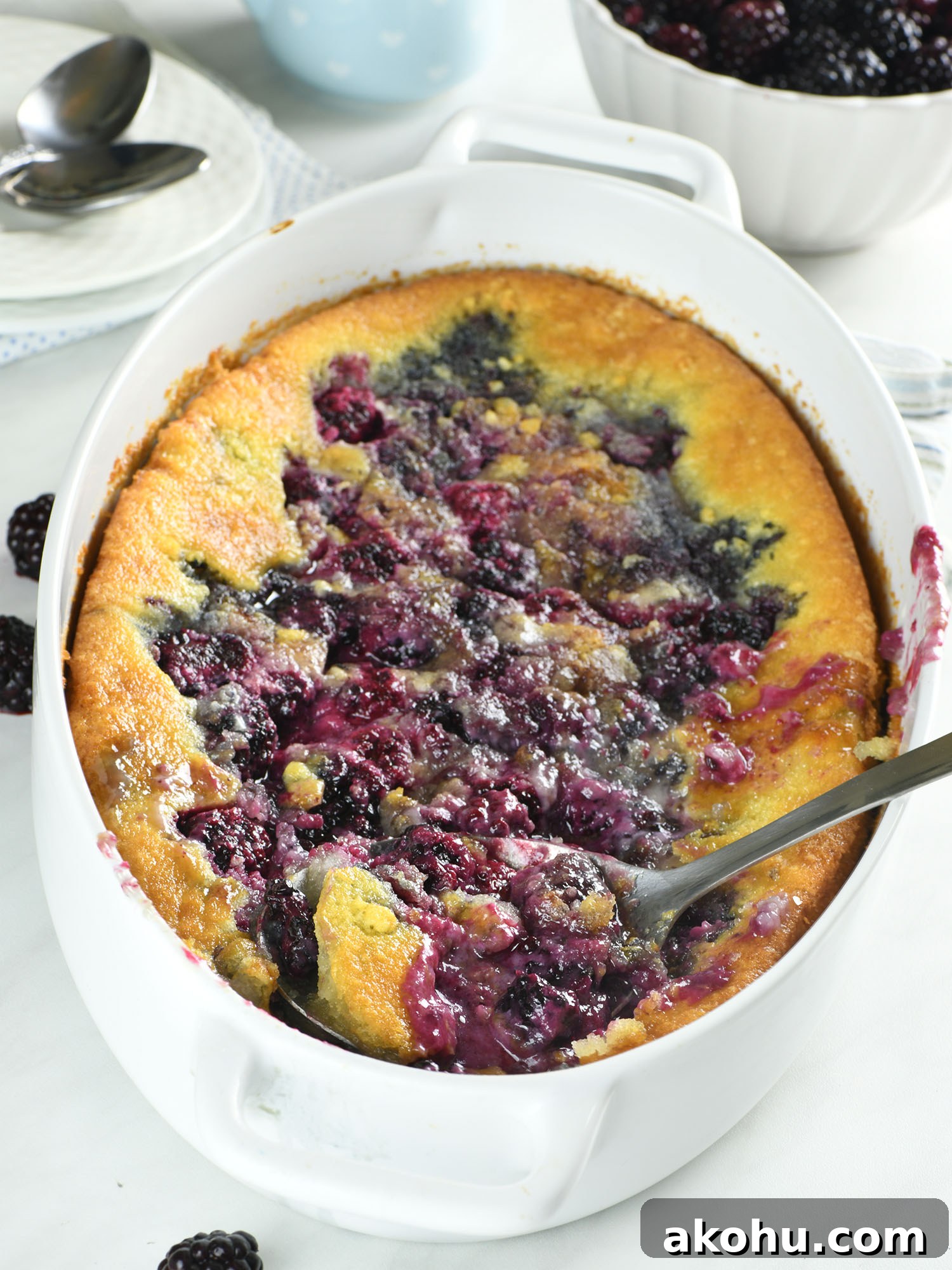 Easy blackberry cobbler being served from a baking dish with juicy blackberries and golden buttery topping.
