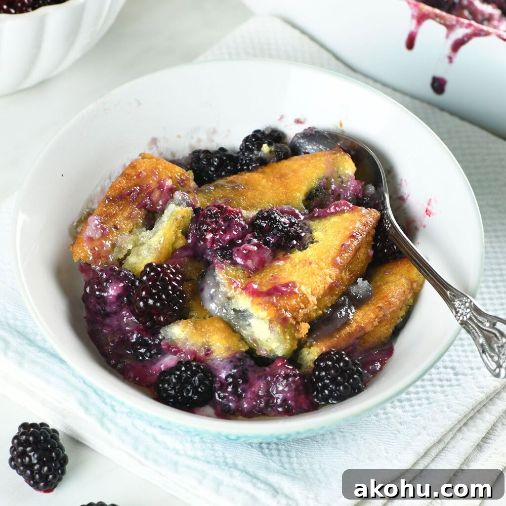Easy blackberry cobbler served in a bowl with juicy blackberries, golden buttery topping, and a spoon.