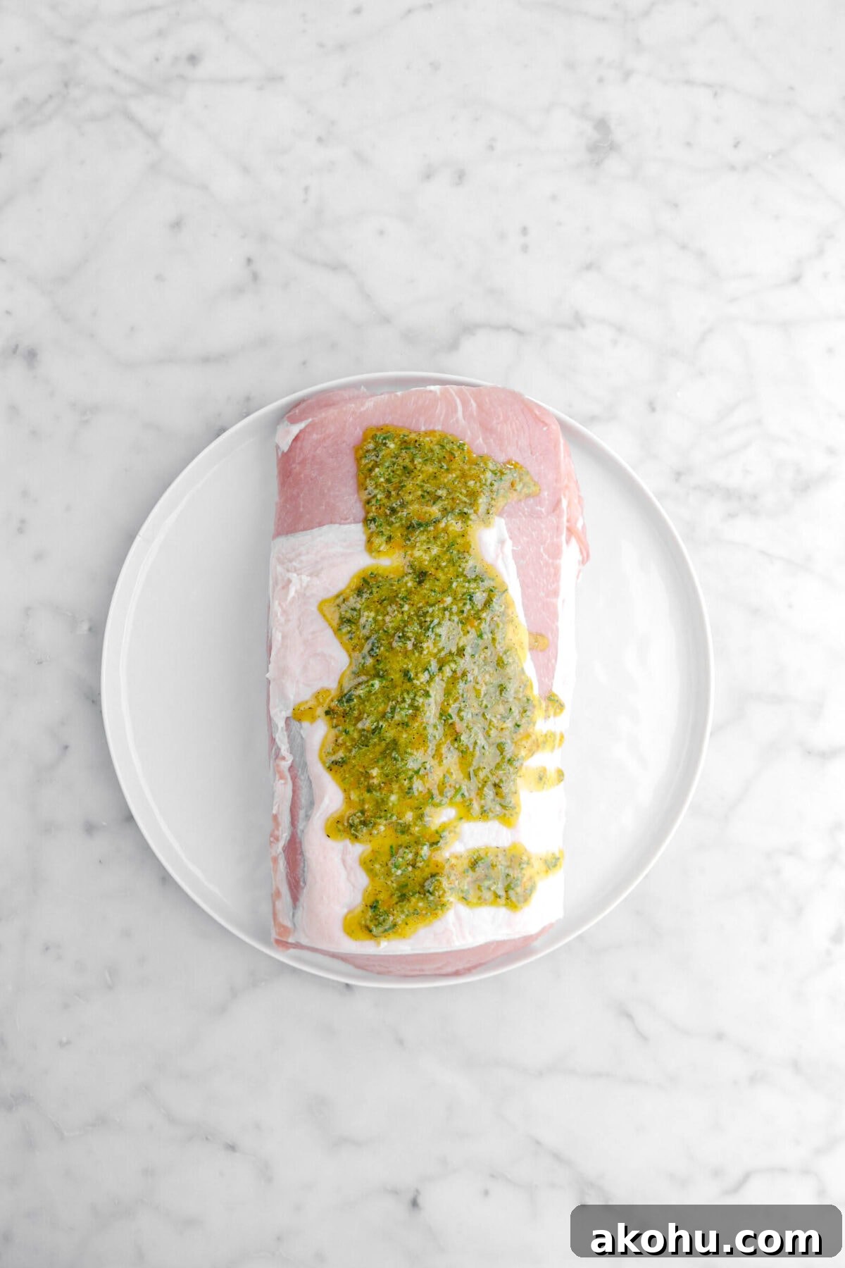 marinade poured over pork on white plate.