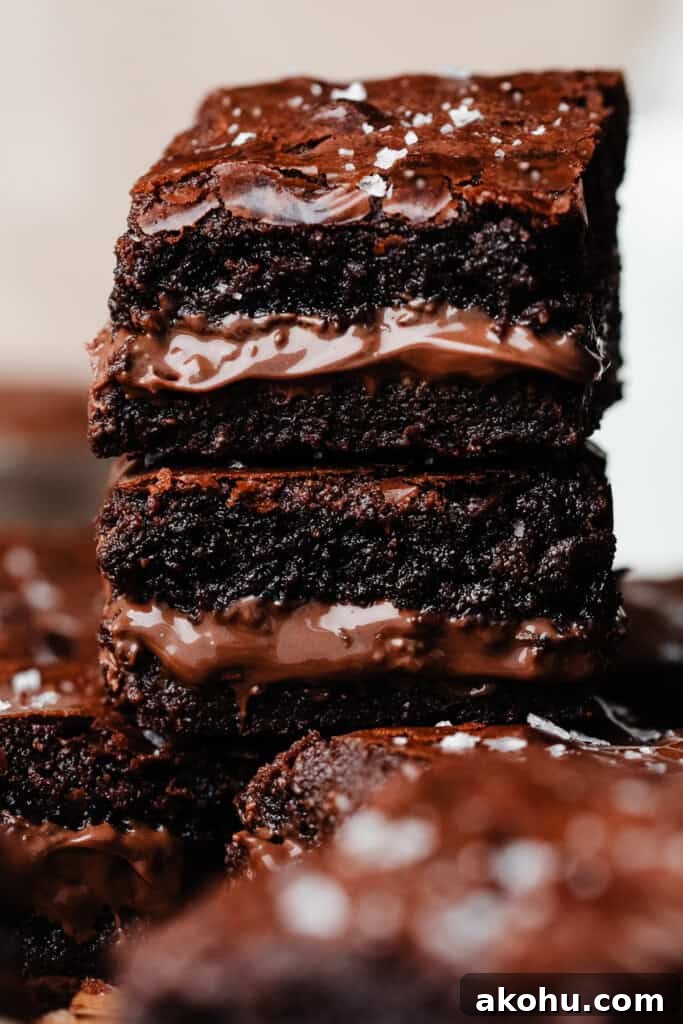 A close-up on a stack of nutella brownies, with a visible ripple of molten nutella in the middles.