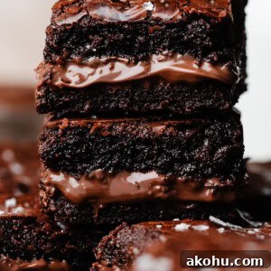 A close-up on a stack of brownies, rippled with luscious nutella in the middle.