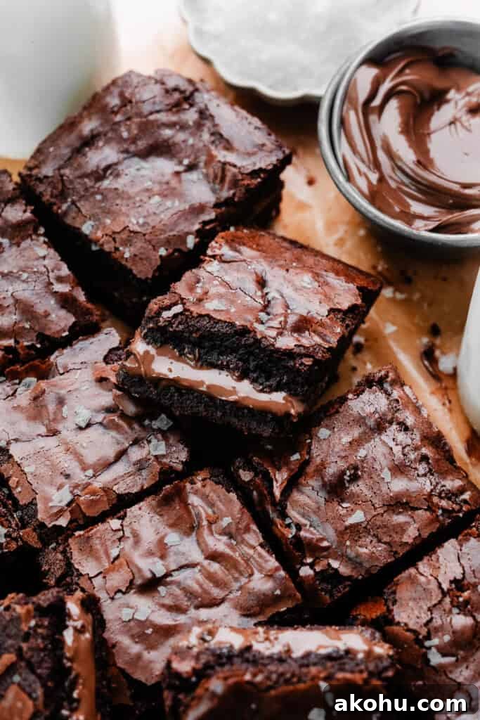Nutella brownies on parchment paper, with a visible nutella ripple in the centers.