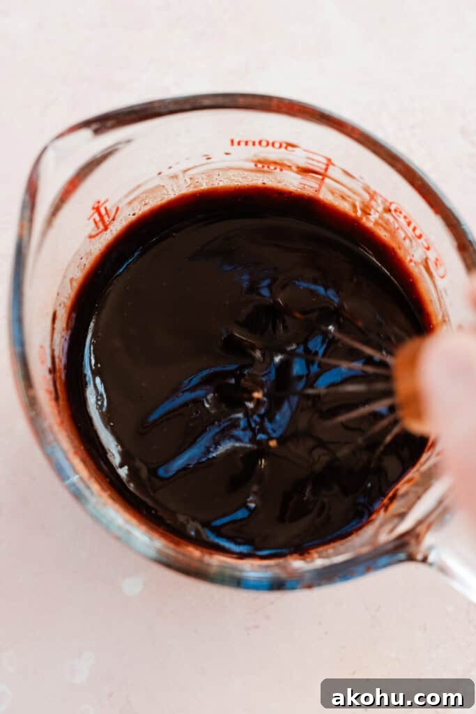 A measuring cup of the butter and chocolate mixture.