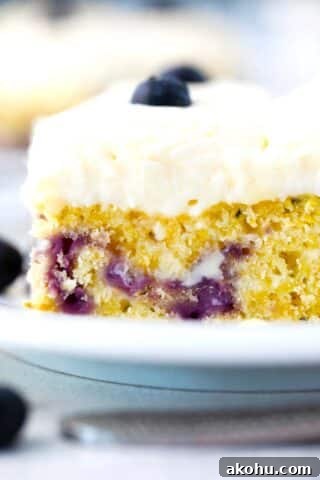 Close shot of a slice of lemon blueberry zucchini poke cake.