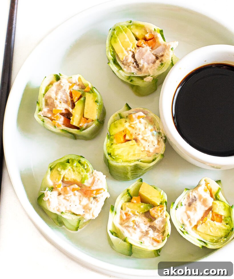 Bites of cucumber sushi roll served on a plate with a side of soy sauce.