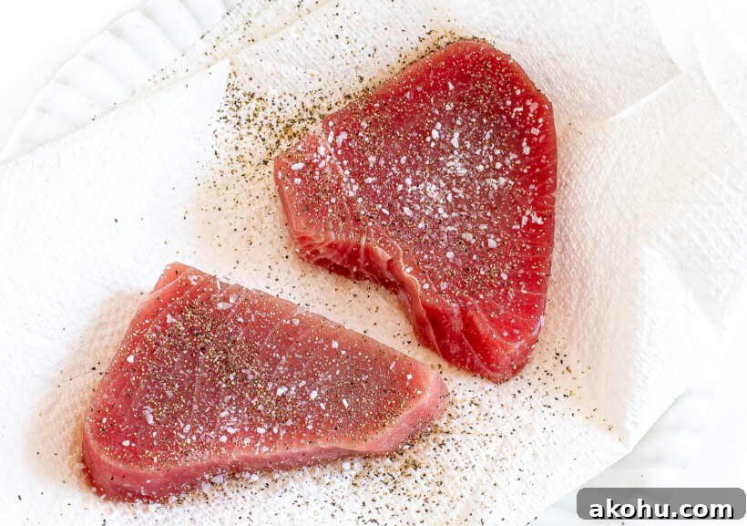 Raw tuna filets seasoned with salt and pepper.