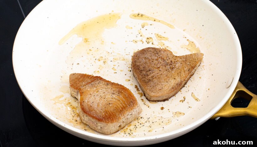 Ahi tuna being seared in a pan.