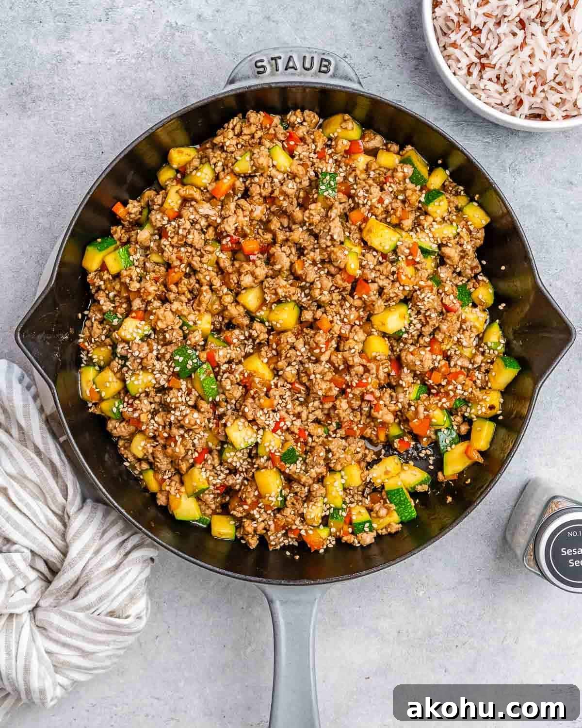 Ground turkey and vegetables in a skillet on a gray background.
