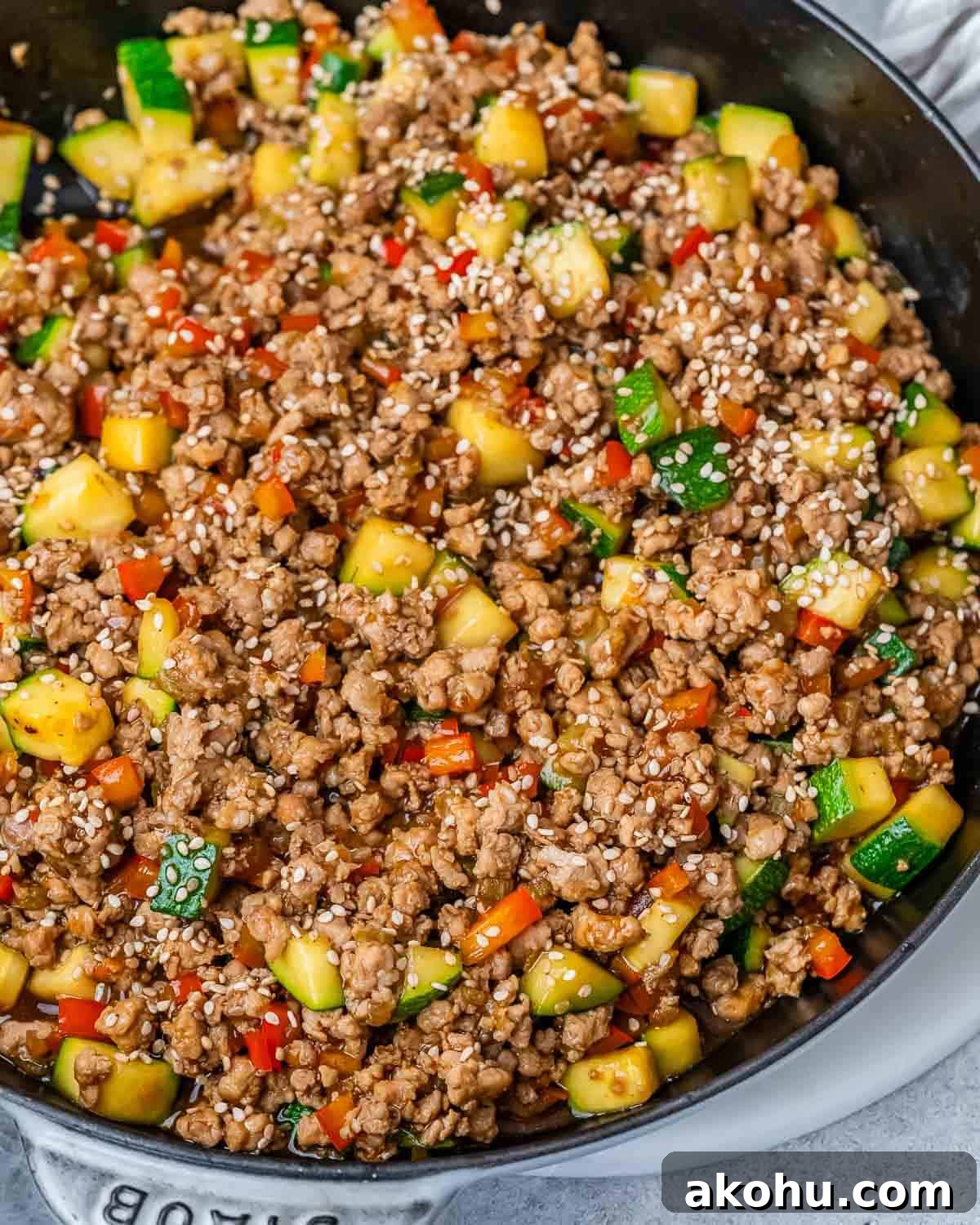 Ground turkey and vegetables in a skillet on a gray background.