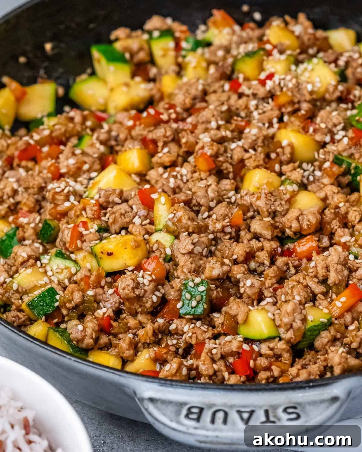 Ground turkey and vegetables in a skillet on a gray background.
