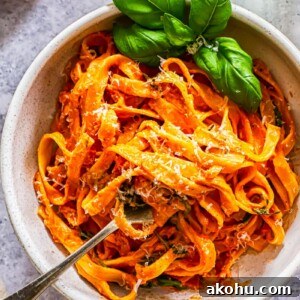 Top down of a bowl of pasta with basil and tomato and mascarpone basil sauce